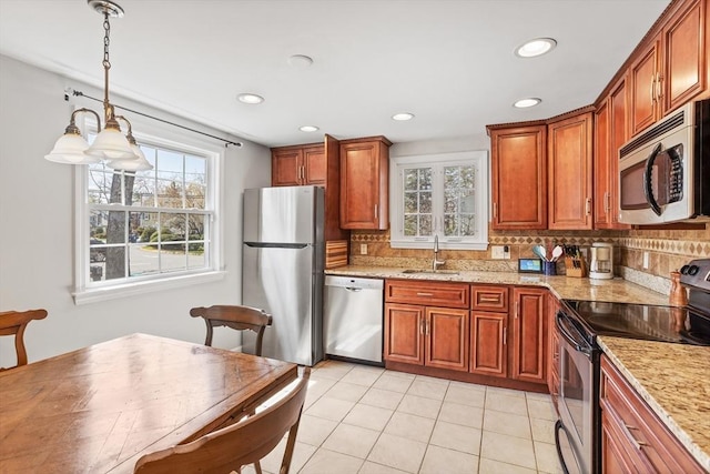 kitchen featuring a sink, tasteful backsplash, a healthy amount of sunlight, and stainless steel appliances