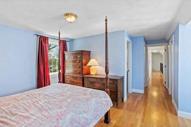 bedroom featuring light wood-style floors and baseboards