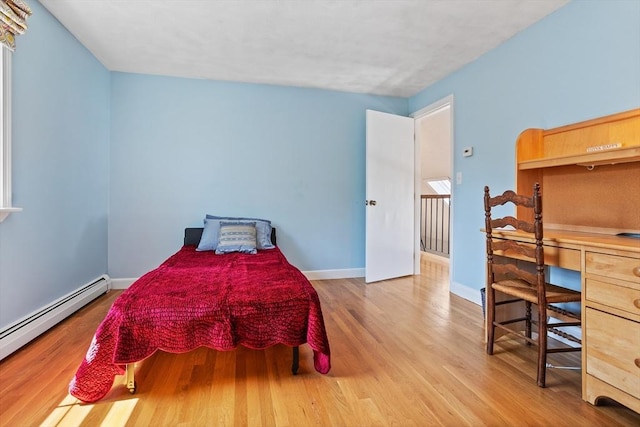 bedroom featuring baseboards, baseboard heating, and wood finished floors