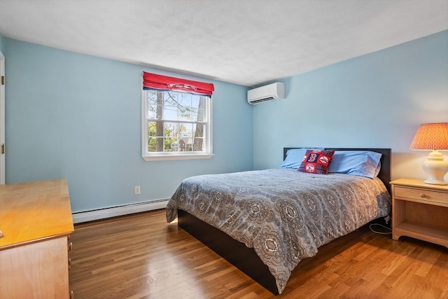 bedroom featuring an AC wall unit, a baseboard radiator, and wood finished floors