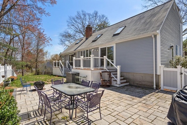 rear view of house with stairs, a fire pit, a chimney, and a patio
