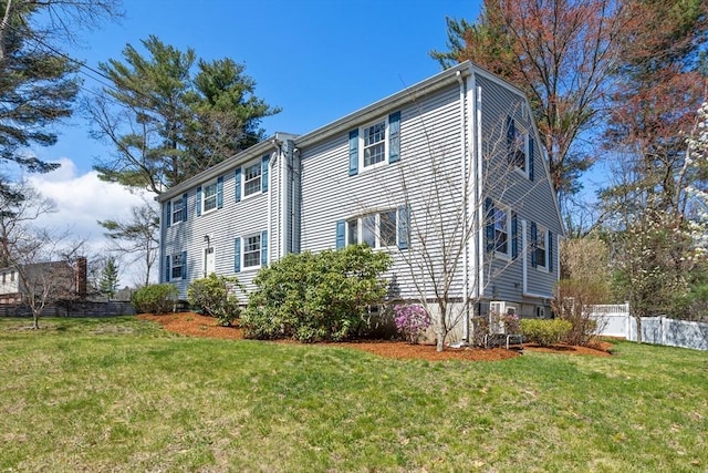 view of property exterior with fence and a yard