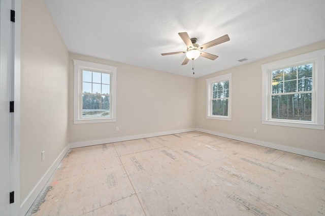 empty room with ceiling fan and a healthy amount of sunlight