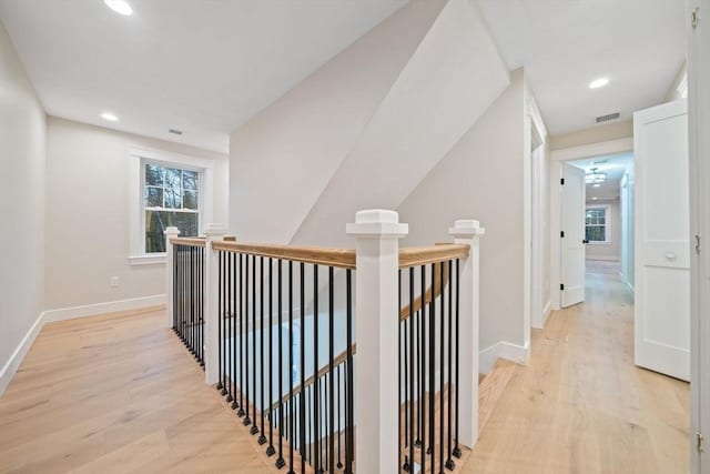 corridor with a wealth of natural light and light hardwood / wood-style floors