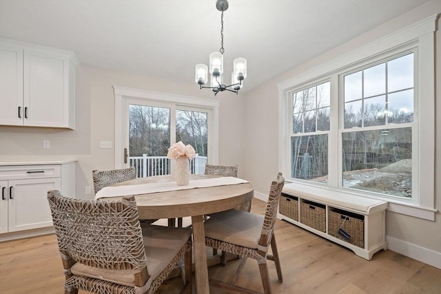 dining room with light hardwood / wood-style flooring and a notable chandelier