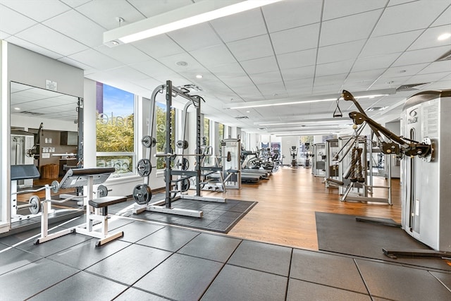 exercise room featuring a paneled ceiling and wood-type flooring