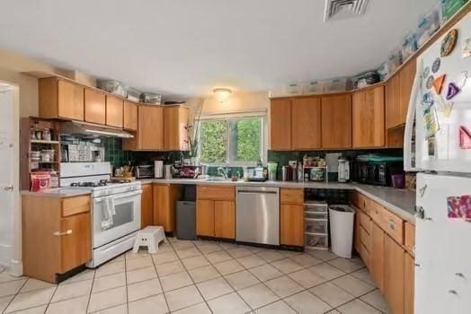 kitchen featuring visible vents, light countertops, white appliances, under cabinet range hood, and backsplash