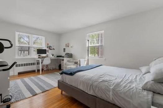 bedroom with radiator and wood finished floors