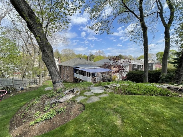 rear view of property with fence and a lawn