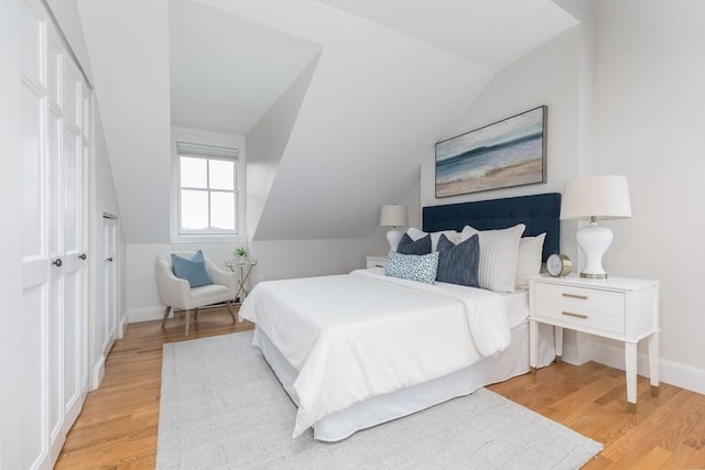 bedroom featuring lofted ceiling and light hardwood / wood-style floors