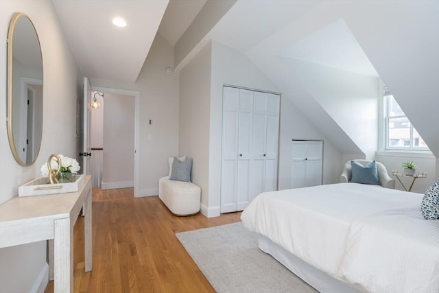 bedroom featuring lofted ceiling and light hardwood / wood-style flooring