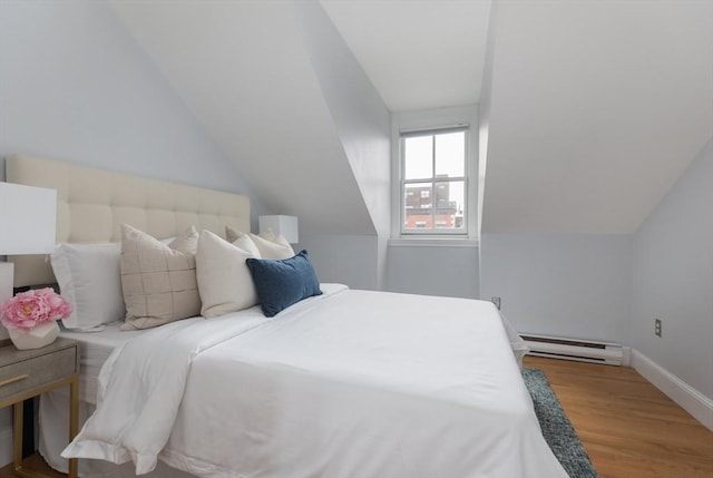 bedroom featuring a baseboard heating unit, vaulted ceiling, and wood-type flooring