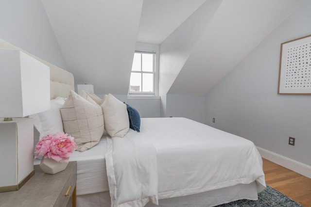 bedroom featuring vaulted ceiling and light hardwood / wood-style floors