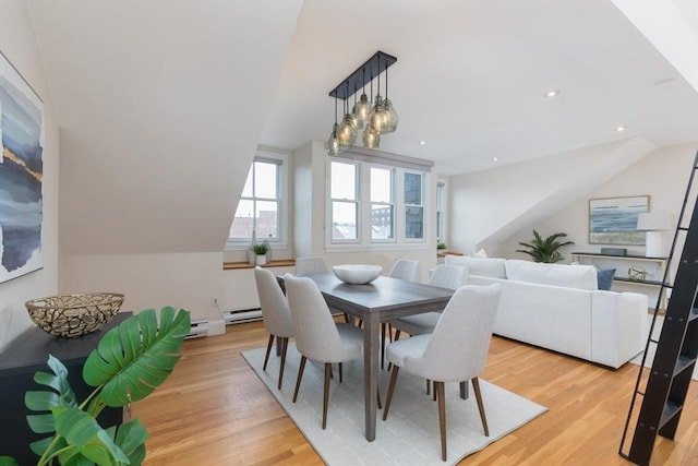 dining space with light wood-type flooring, baseboard heating, and lofted ceiling