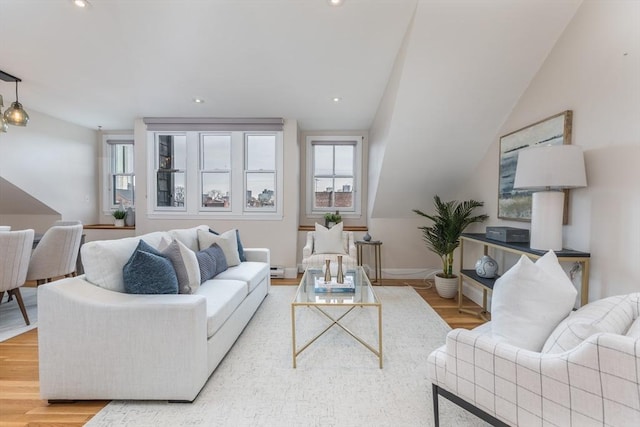 living room with light hardwood / wood-style floors and vaulted ceiling