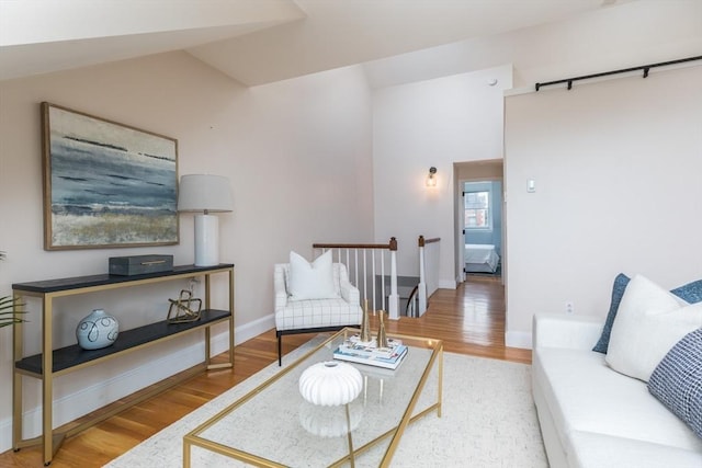 living room featuring vaulted ceiling and hardwood / wood-style floors