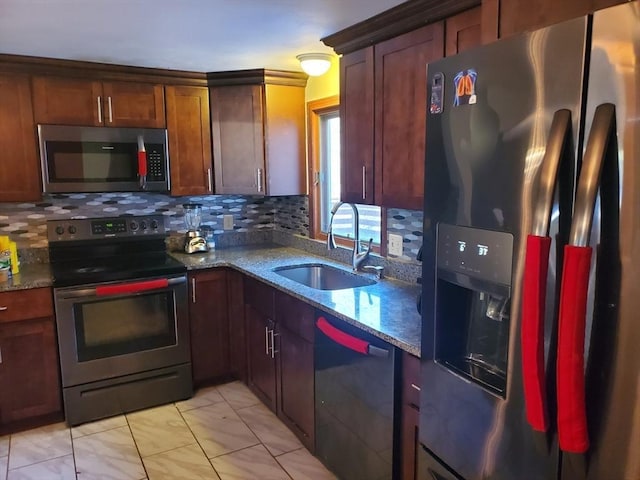 kitchen with decorative backsplash, sink, dark stone counters, and appliances with stainless steel finishes