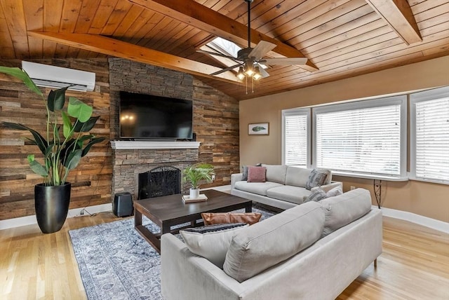 living room with wood finished floors, vaulted ceiling with beams, a stone fireplace, and a wall mounted AC