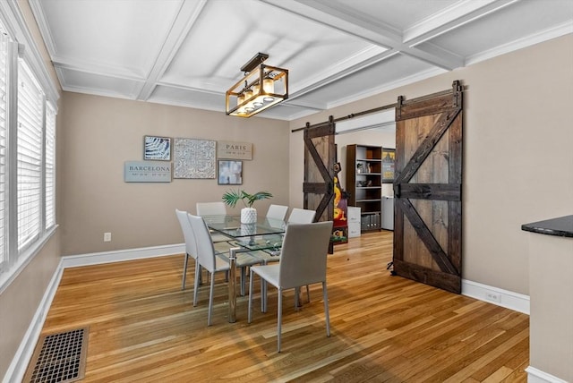 dining room with coffered ceiling, visible vents, light wood finished floors, and a barn door