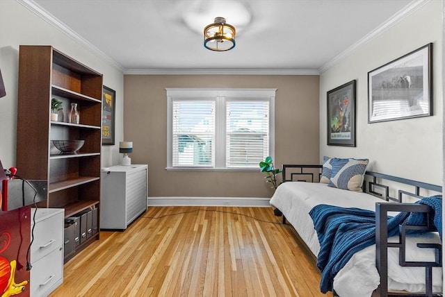 bedroom with crown molding, light wood-style flooring, and baseboards