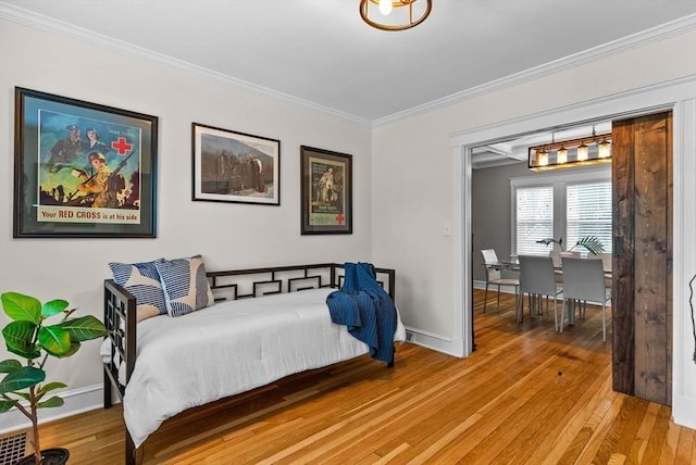 bedroom with light wood-type flooring, baseboards, and ornamental molding