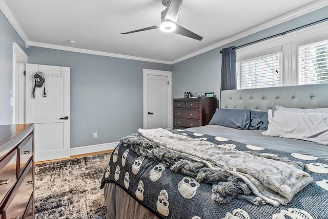 bedroom with a ceiling fan, crown molding, baseboards, and wood finished floors