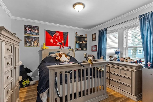 bedroom with light wood-style floors and crown molding