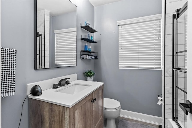 full bathroom featuring baseboards, vanity, and toilet