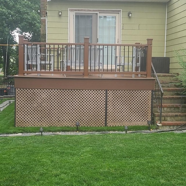 rear view of house featuring a deck and a lawn