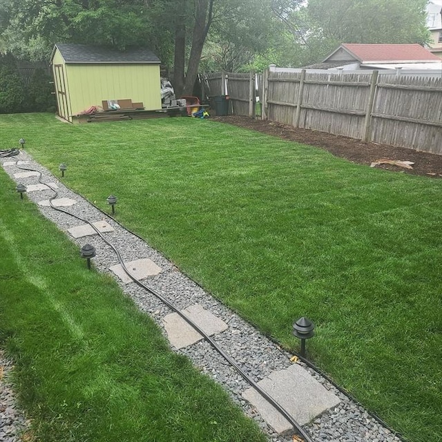 view of yard with fence and an outbuilding