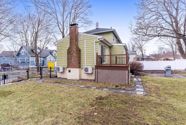 rear view of house featuring a residential view, a lawn, a chimney, and fence