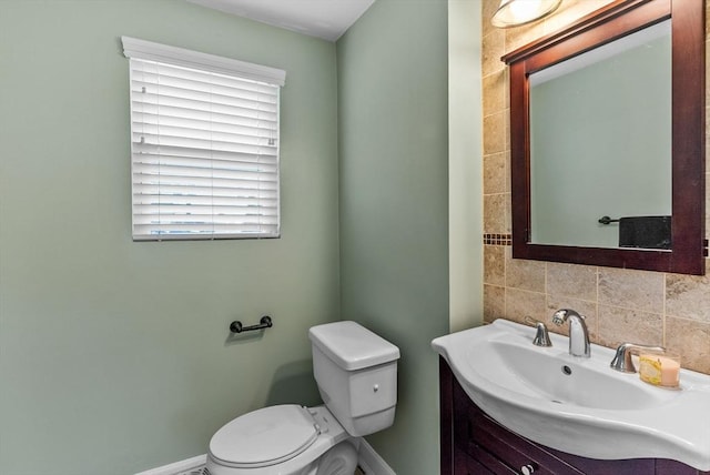 bathroom featuring baseboards, backsplash, toilet, and vanity