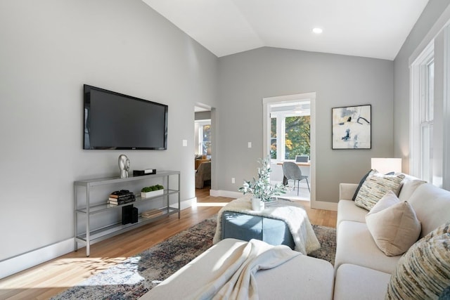 living room featuring vaulted ceiling and light wood-type flooring