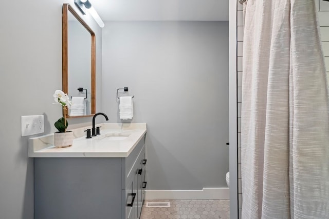 bathroom featuring vanity, a shower with shower curtain, toilet, and tile patterned floors