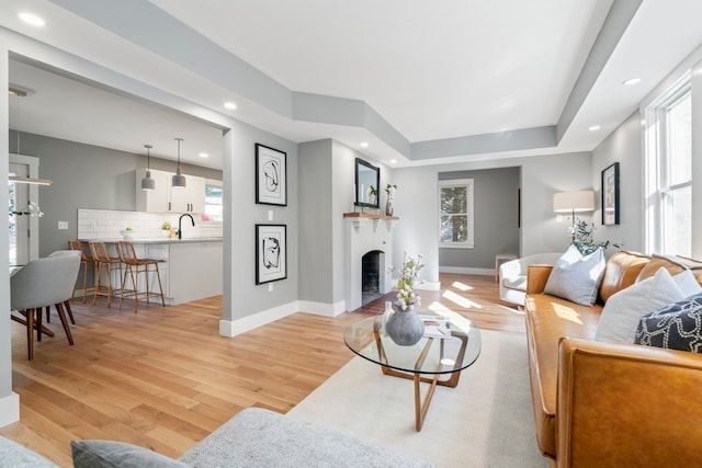 living room with sink and light wood-type flooring