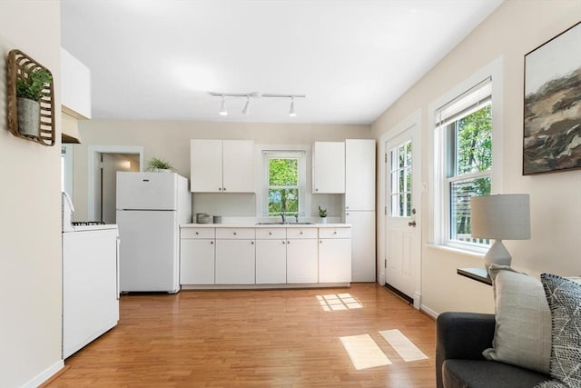 1 Batchelder Ave, North Reading, MA 01864 - kitchen with freestanding refrigerator, a sink, range, white cabinets, and light wood-style floors