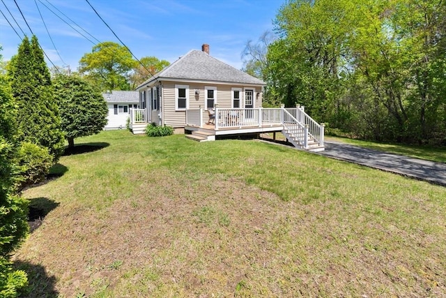 1 Batchelder Ave, North Reading, MA 01864 - rear view of house with a lawn, a chimney, a deck, and a shingled roof