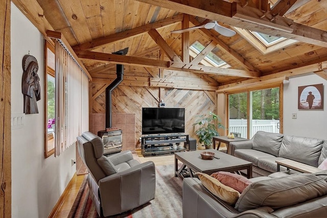 81 Baldwin Rd, Billerica, MA 01821 - living area featuring a wood stove, a skylight, wooden ceiling, wood walls, and a ceiling fan