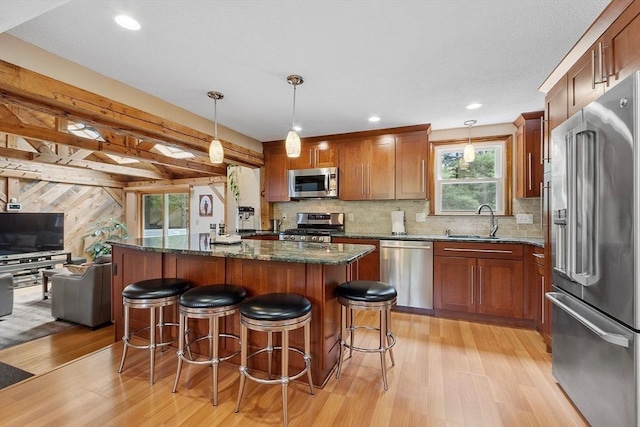 81 Baldwin Rd, Billerica, MA 01821 - kitchen with appliances with stainless steel finishes, light wood finished floors, a kitchen island, a breakfast bar, and recessed lighting