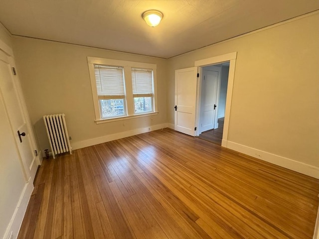 spare room with wood-type flooring and radiator heating unit