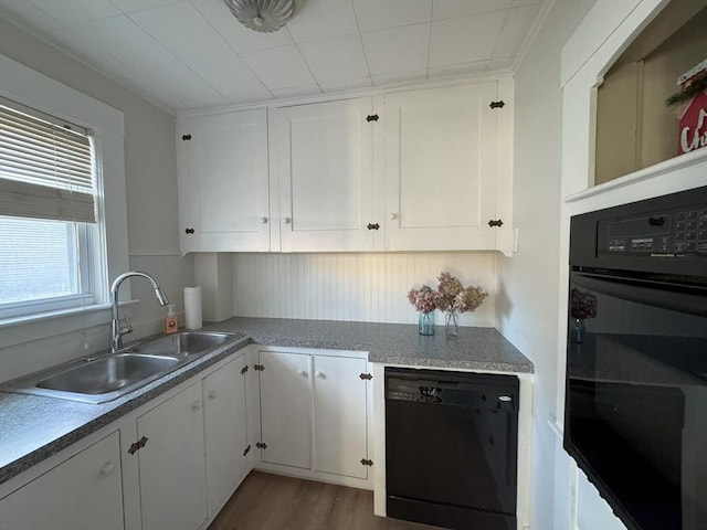 kitchen with sink, white cabinetry, dark wood-type flooring, and black appliances