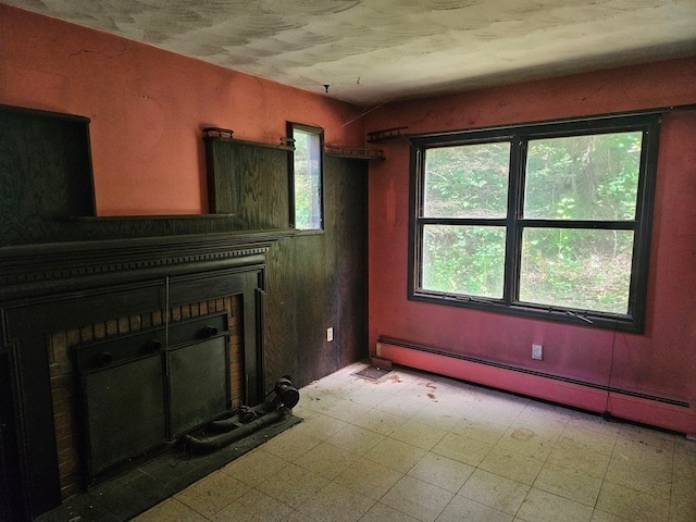 unfurnished living room featuring a baseboard heating unit and a brick fireplace