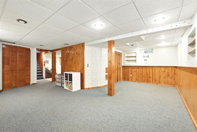 19 Arnold Ave, Chicopee, MA 01013 - finished below grade area featuring a paneled ceiling, carpet, stairs, wooden walls, and baseboards