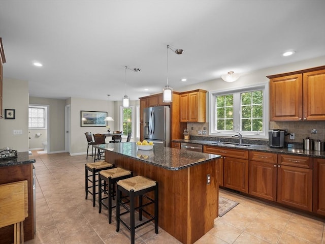 66 Saville, North Andover, MA 01845 - kitchen with stainless steel appliances, a sink, backsplash, light tile patterned flooring, and a kitchen island