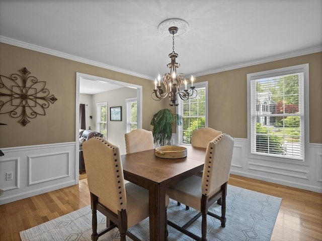 66 Saville, North Andover, MA 01845 - dining space featuring a chandelier, light wood-type flooring, wainscoting, ornamental molding, and a decorative wall