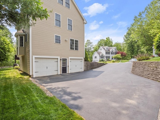 66 Saville, North Andover, MA 01845 - view of side of property featuring driveway, central AC unit, an attached garage, and a lawn