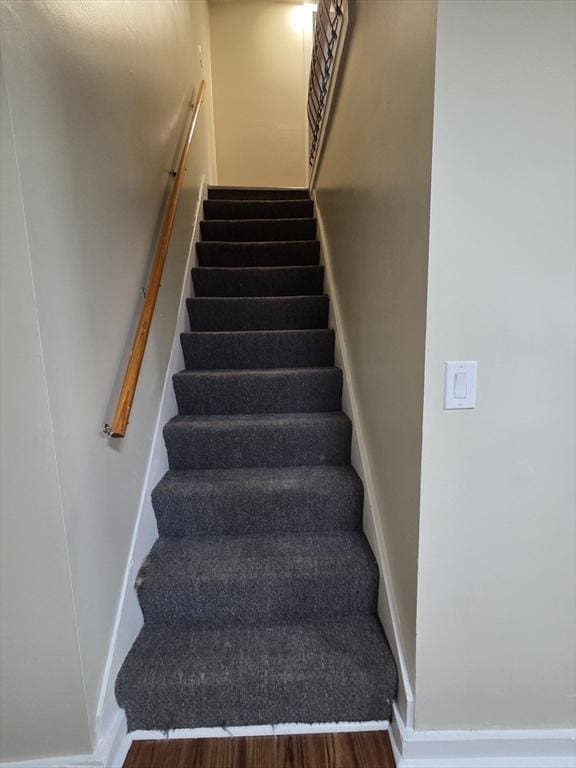 stairs featuring baseboards and wood finished floors
