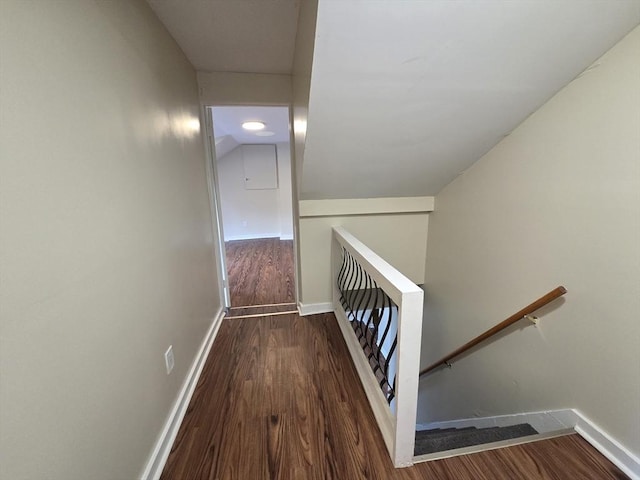staircase featuring baseboards and wood finished floors