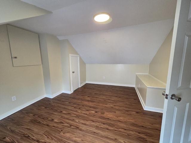bonus room featuring baseboards, vaulted ceiling, and dark wood-type flooring