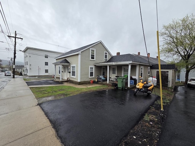 view of front facade featuring driveway and a chimney